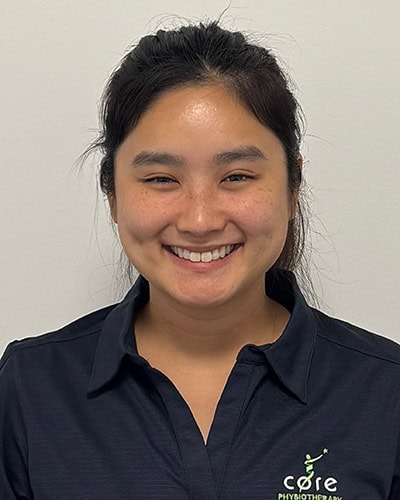 Therapist smiling in sportswear at Core Physio & Pilates clinic in Australia.