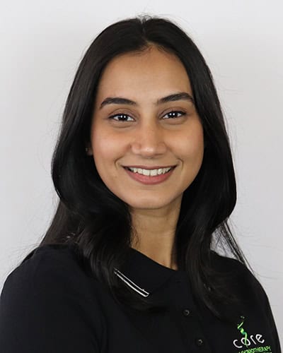 Smiling woman in black uniform at Core Physio & Pilates clinic.